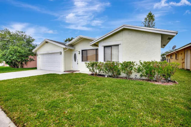 a view of a house with yard and tree s