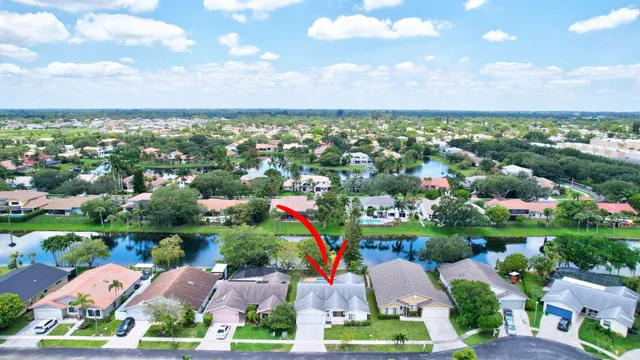 an aerial view of residential house with outdoor space and lake view in back