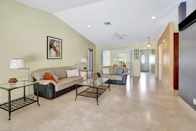 a living room with furniture and a view of kitchen