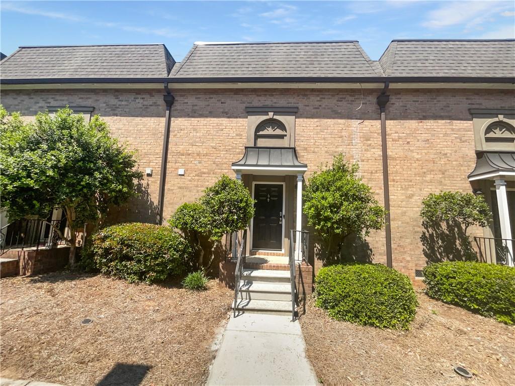 6980 Roswell Road, Unit J6 Atlanta, GA 30328 - Photo 1 of 1 a front view of a house with a yard