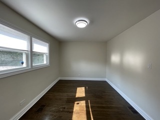 9042 South Lowe Avenue Chicago, IL 60620 - Photo 7 of 16 an empty room with wooden floor and windows