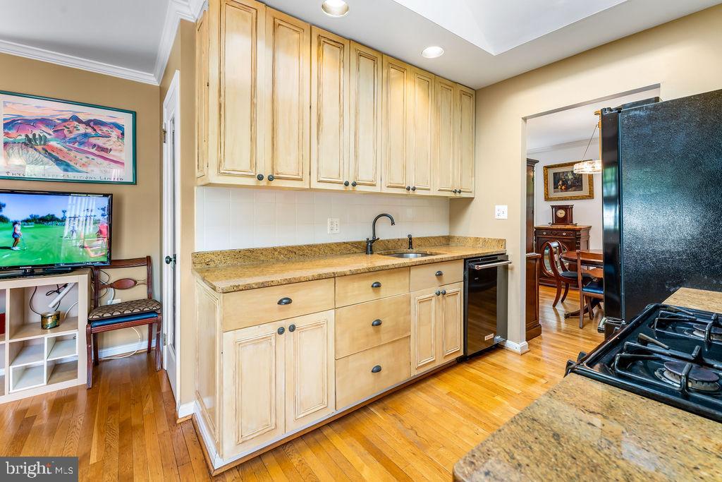 1329 Gresham Road Silver Spring, MD 20904 - Photo 11 of 56 a kitchen with stainless steel appliances granite countertop a stove a sink and a refrigerator with wooden floor
