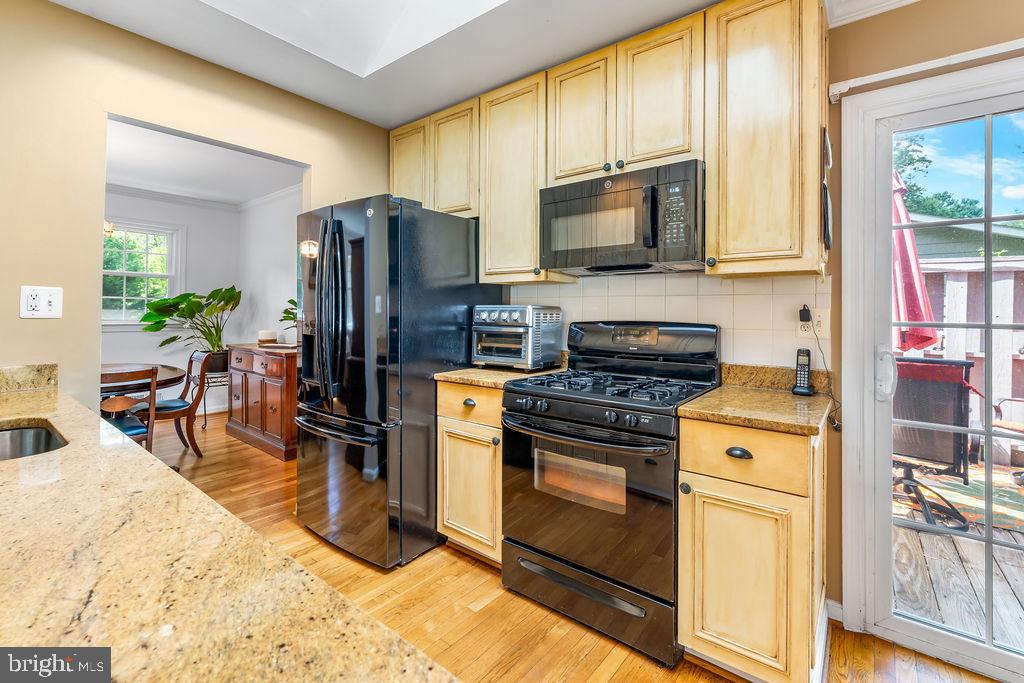 1329 Gresham Road Silver Spring, MD 20904 - Photo 12 of 56 a kitchen with stainless steel appliances granite countertop a stove a refrigerator and a microwave oven