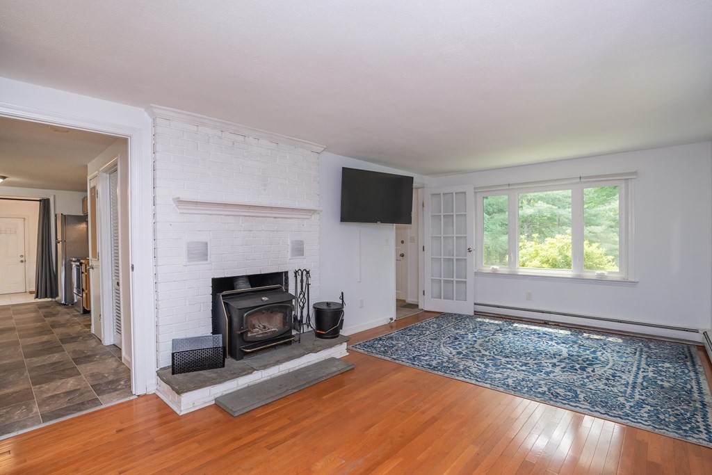 80 Goodell Street Belchertown, MA 01007 - Photo 24 of 40 a living room with furniture a flat screen tv and a fireplace