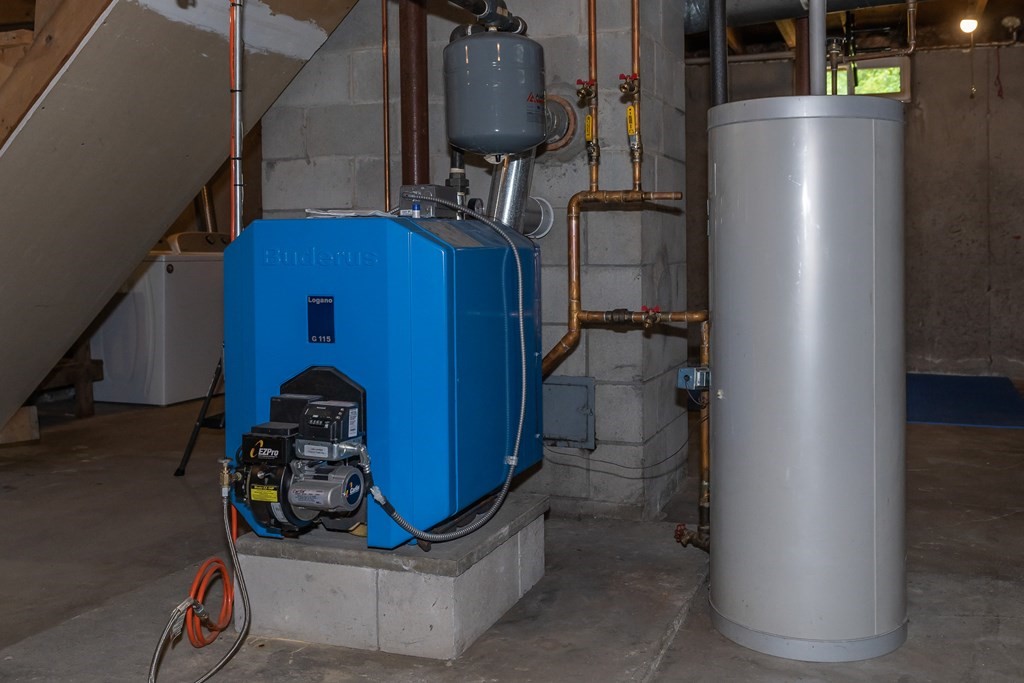 80 Goodell Street Belchertown, MA 01007 - Photo 39 of 40 a room with water heater and wooden cabinets