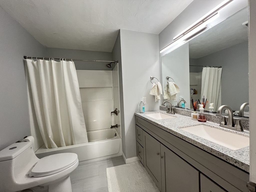 46 Suomi Road, Unit 46 Quincy, MA 02169 - Photo 14 of 16 a bathroom with a granite countertop sink toilet and shower
