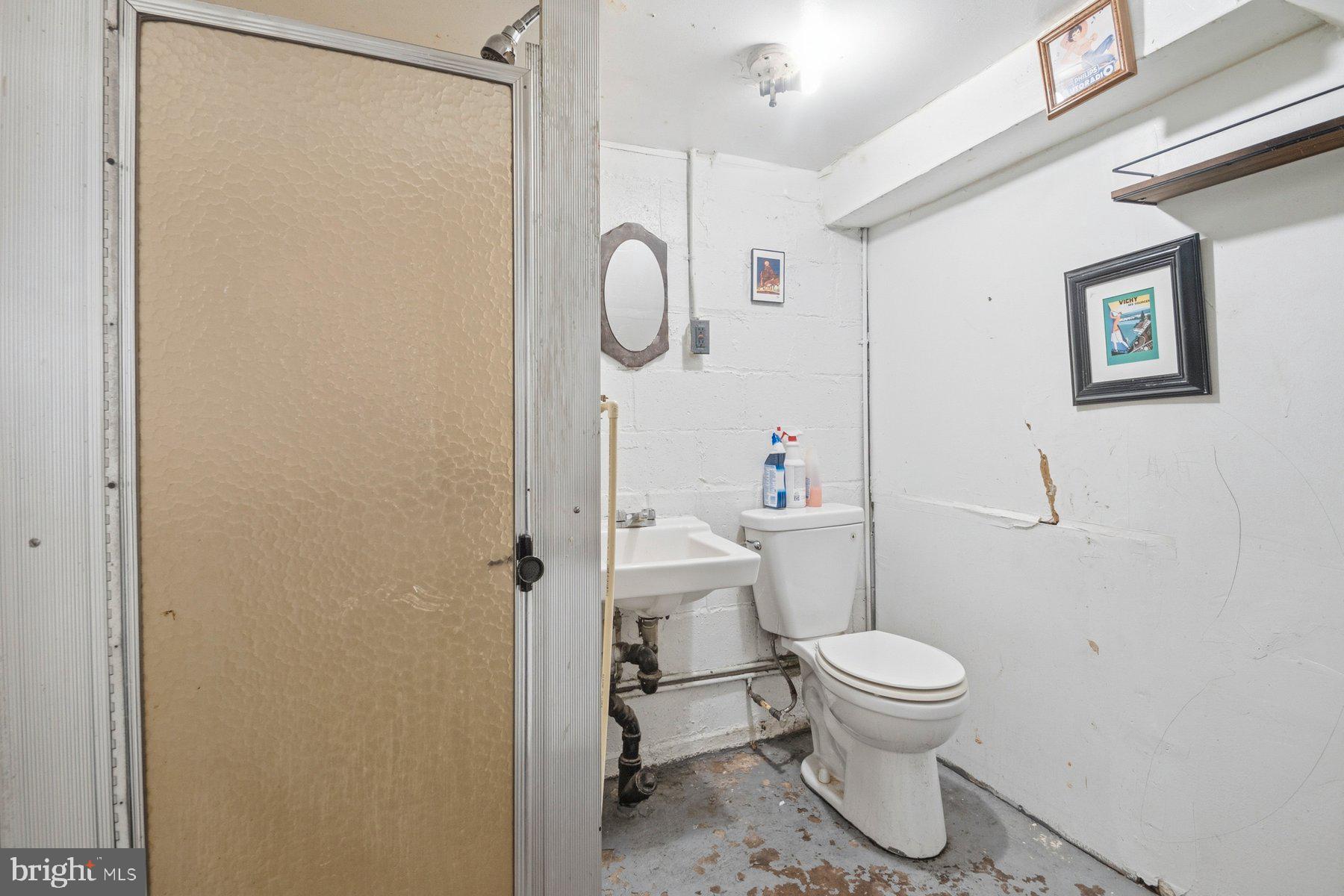 4931 Brookwood Road Baltimore, MD 21225 - Photo 25 of 25 a white toilet sitting next to a bathroom sink