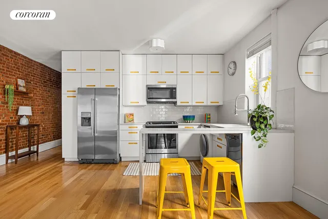 a kitchen with stainless steel appliances a stove a refrigerator and a potted plant