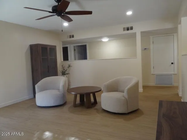 a living room with furniture and a ceiling fan