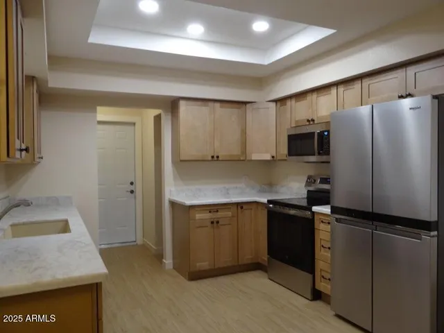 a kitchen with a sink a stove a refrigerator a microwave a sink and cabinets