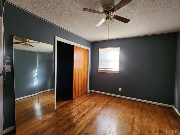 an empty room with windows and fan