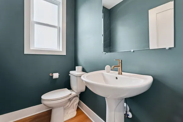 a bathroom with a sink a toilet and mirror