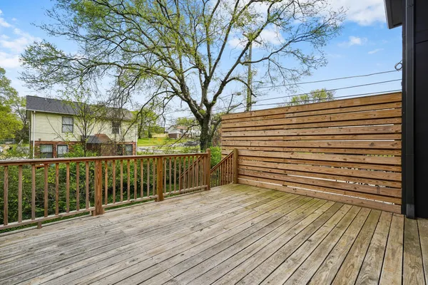 a view of a balcony with wooden floor and fence