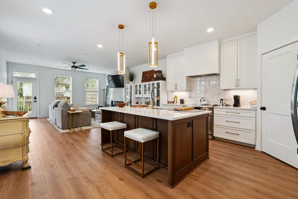 a kitchen with granite countertop a sink cabinets and wooden floor