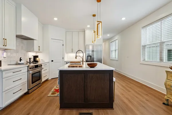 a kitchen with a sink a stove and cabinets