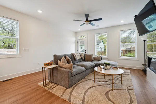 a living room with furniture a ceiling fan and a window