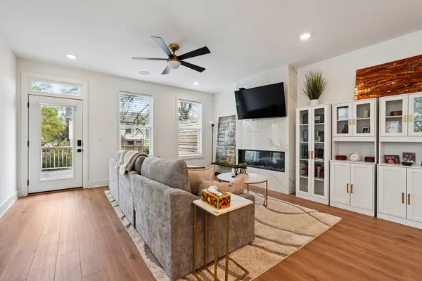 a living room with furniture a flat screen tv and a fireplace