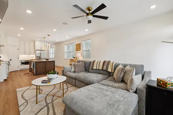 a living room with furniture and kitchen view