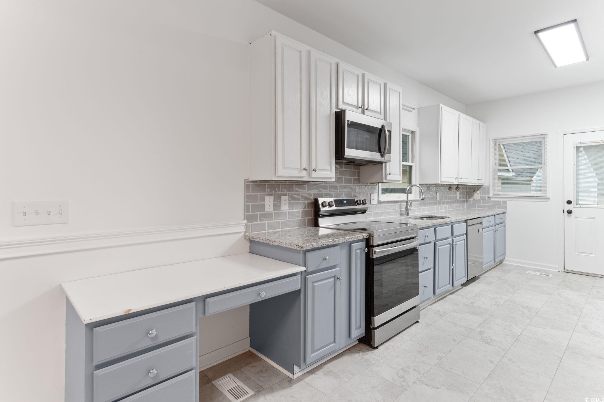 2321 Brick Drive Longs, SC 29568 - Photo 16 of 40 Kitchen with gray cabinets, appliances with stainless steel finishes, decorative backsplash, and white cabinetry