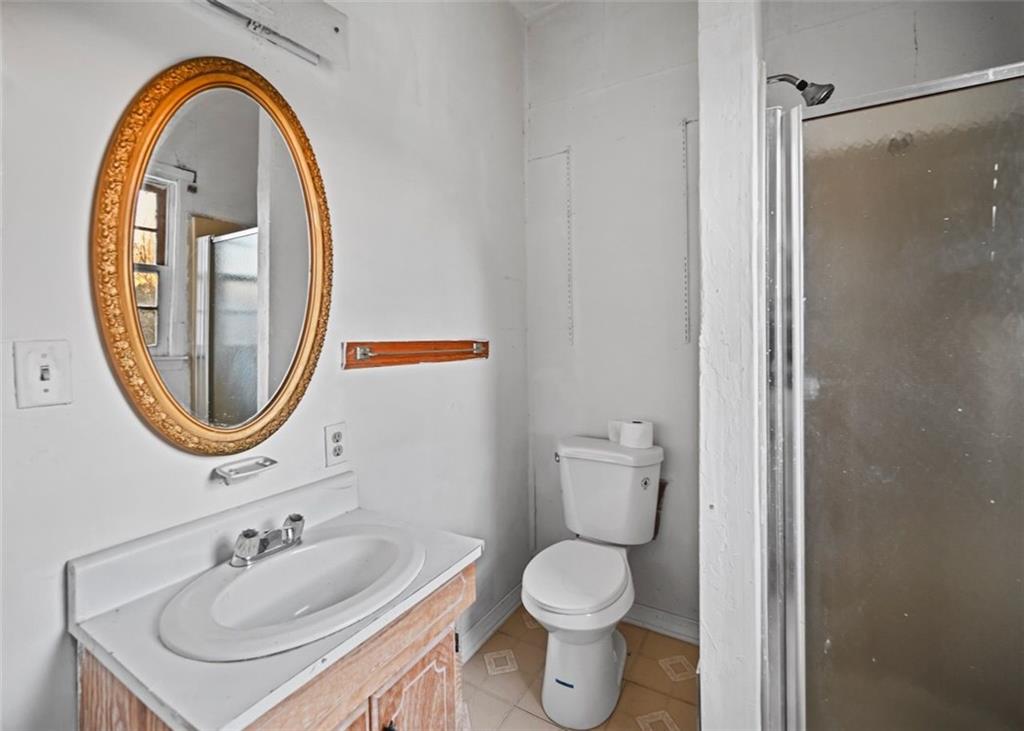 4000 Bostwick Road Madison, GA 30650 - Photo 18 of 34 a bathroom with a sink a mirror a toilet and a shower