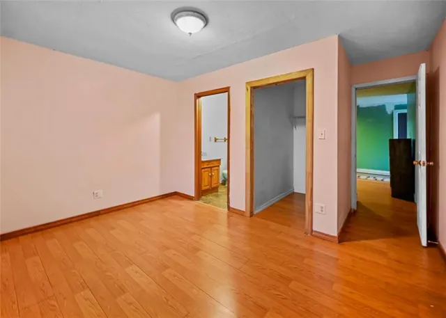 an empty room with wooden floor and closet