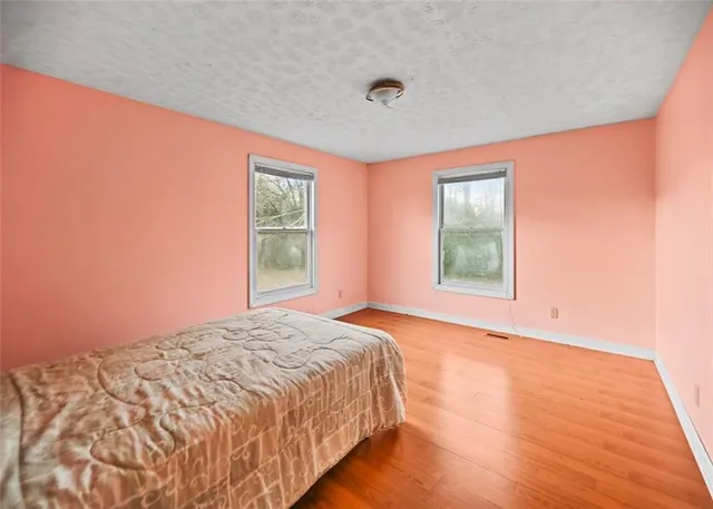 a large bed sitting in a bedroom next to a window