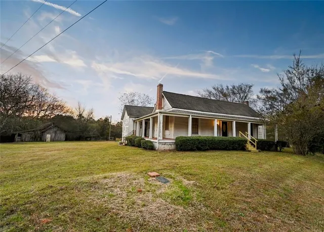 a front view of house with yard and trees in the background