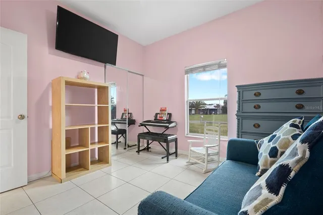 a living room with furniture a flat screen tv and kitchen view