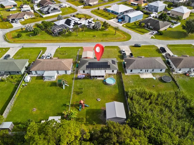an aerial view of residential houses with outdoor space and tennis court