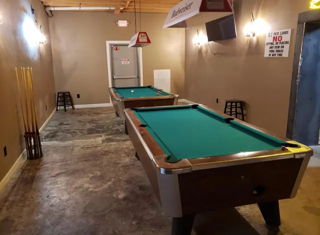 a room with pool table and windows