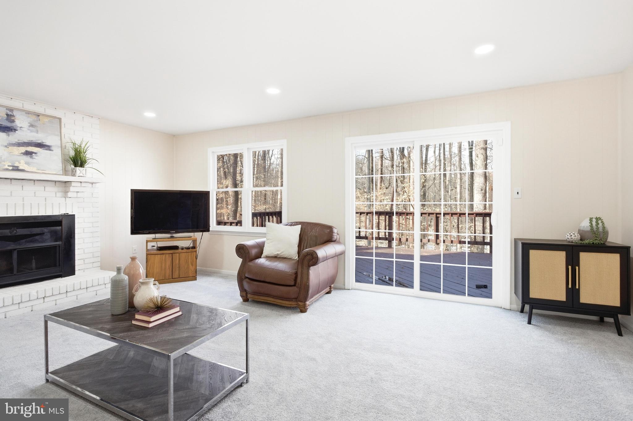 11316 Robert Carter Road Fairfax Station, VA 22039 - Photo 29 of 56 a living room with furniture a flat screen tv and a fireplace