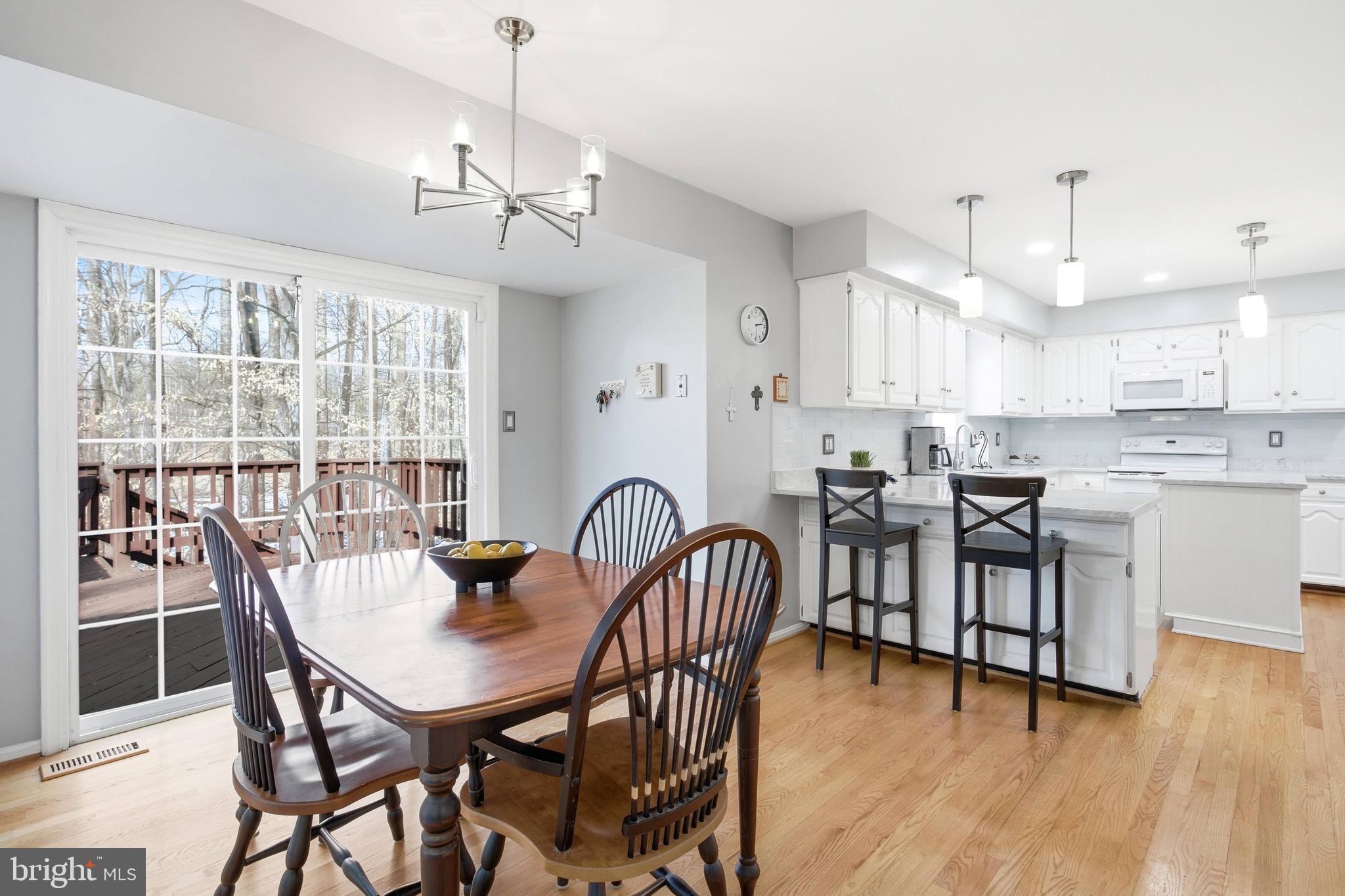 11316 Robert Carter Road Fairfax Station, VA 22039 - Photo 30 of 56 a dining room with furniture a chandelier and wooden floor