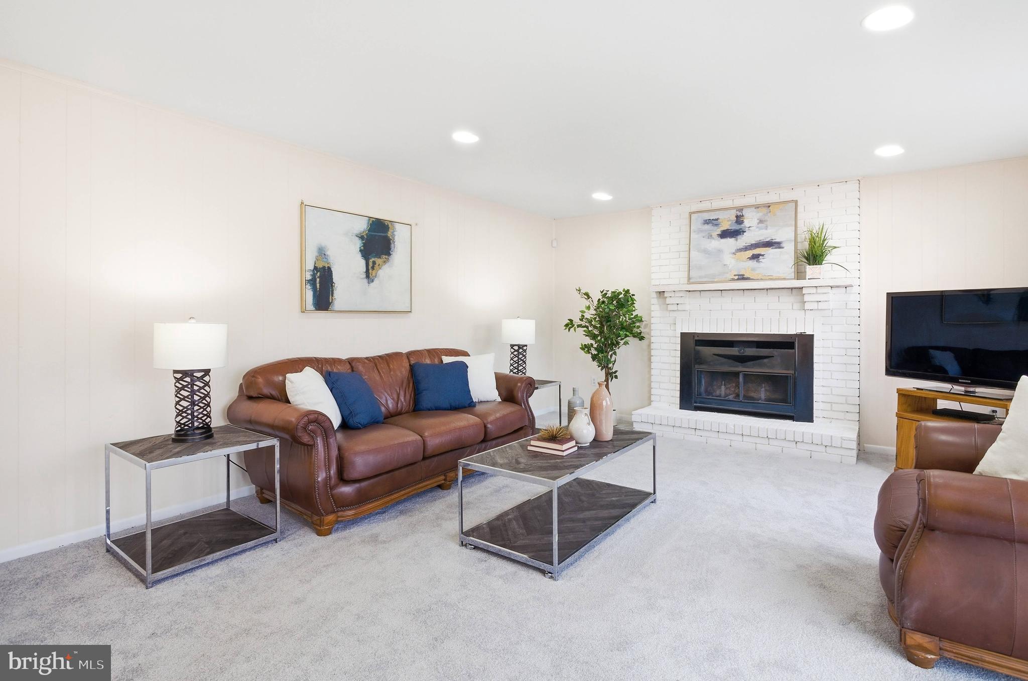 11316 Robert Carter Road Fairfax Station, VA 22039 - Photo 4 of 56 a living room with furniture a flat screen tv and a fireplace