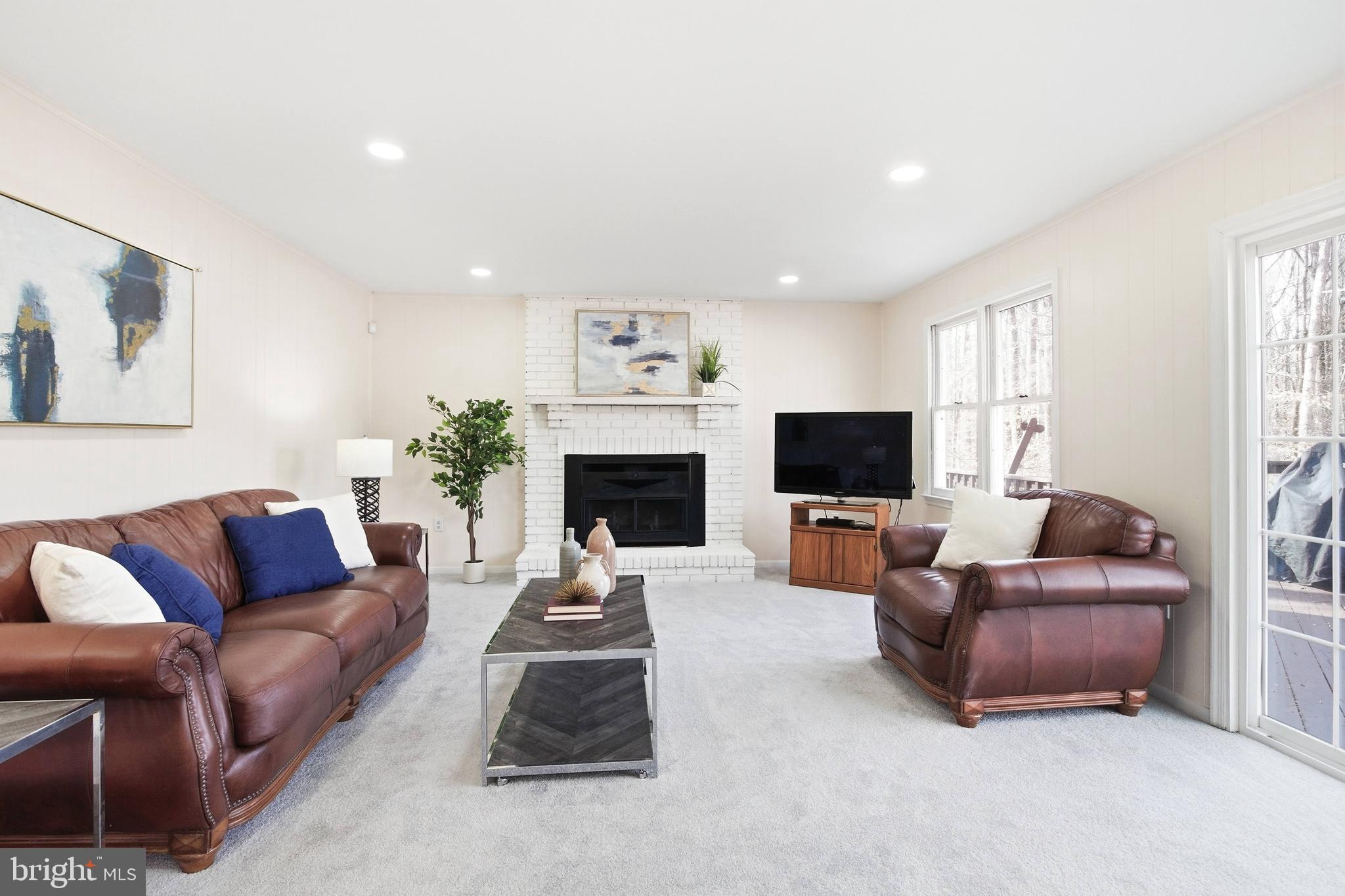 11316 Robert Carter Road Fairfax Station, VA 22039 - Photo 5 of 56 a living room with furniture a flat screen tv and a fireplace
