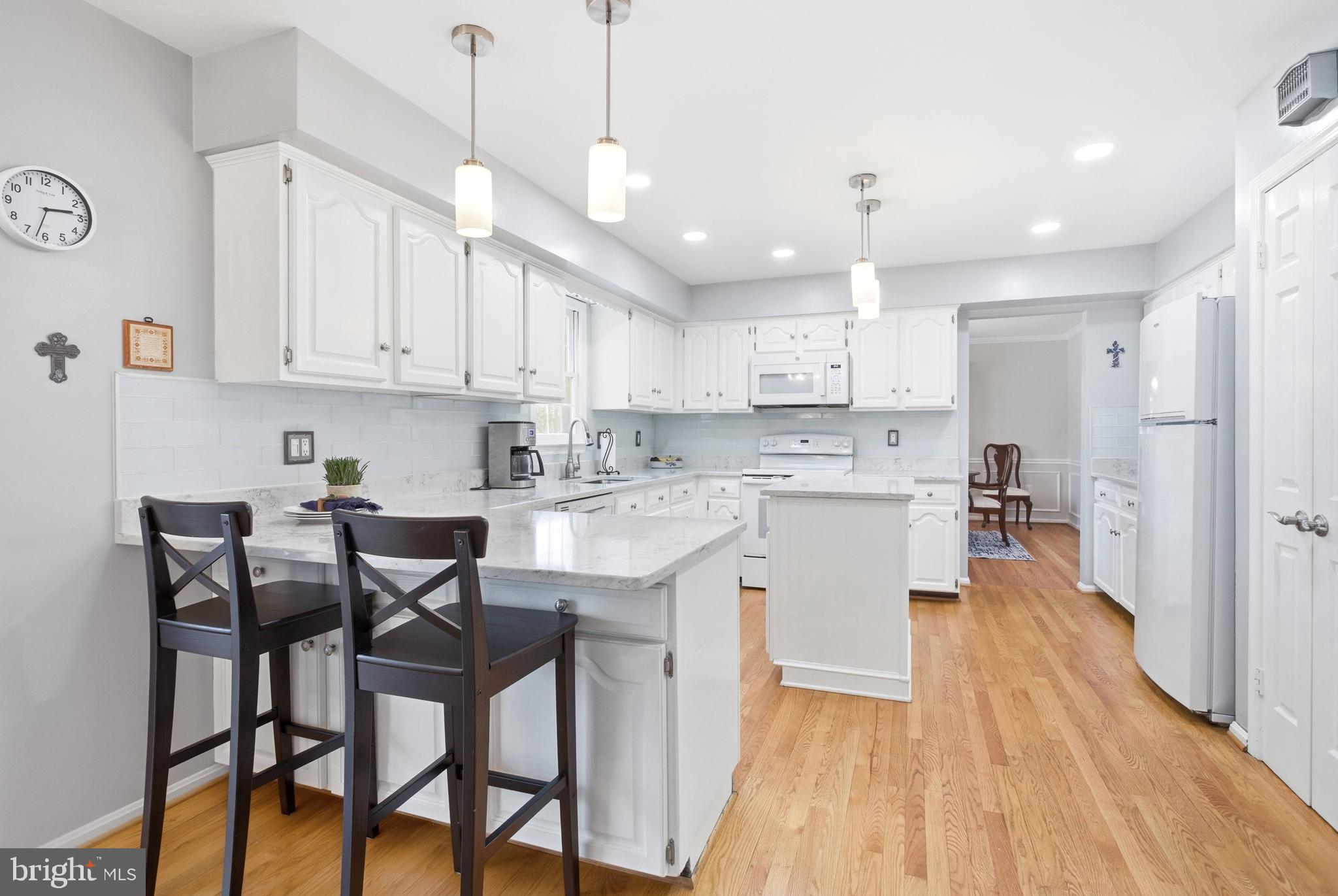 11316 Robert Carter Road Fairfax Station, VA 22039 - Photo 6 of 56 a kitchen with stainless steel appliances granite countertop a stove top oven a refrigerator a sink and chairs