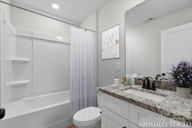a bathroom with a granite countertop sink a toilet and shower