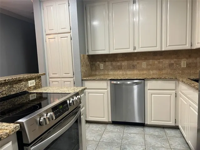 a kitchen with white cabinets and a stove