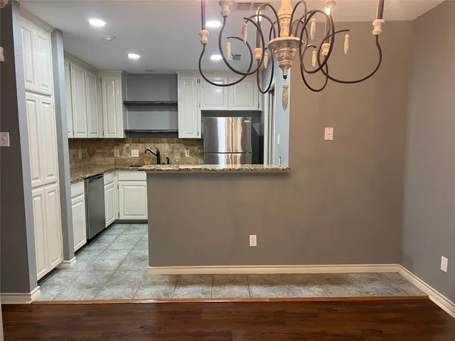 a view of a kitchen with cabinets and wooden floor