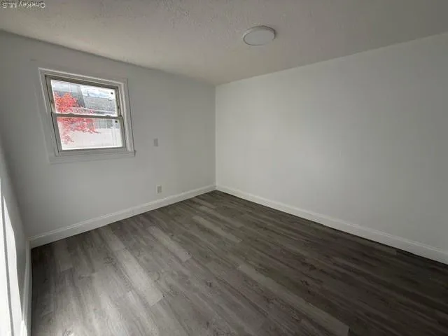 a view of a room with wooden floor and white walls