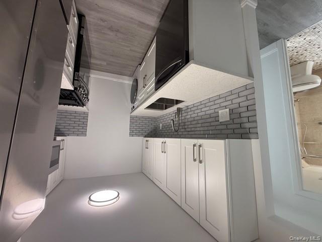 306 Hamilton Avenue, Unit 1 Hewlett, NY 11557 - Photo 4 of 18 a kitchen with a sink stove and cabinets