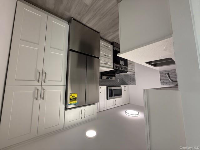 306 Hamilton Avenue, Unit 1 Hewlett, NY 11557 - Photo 8 of 18 a kitchen with stainless steel appliances a refrigerator sink and microwave