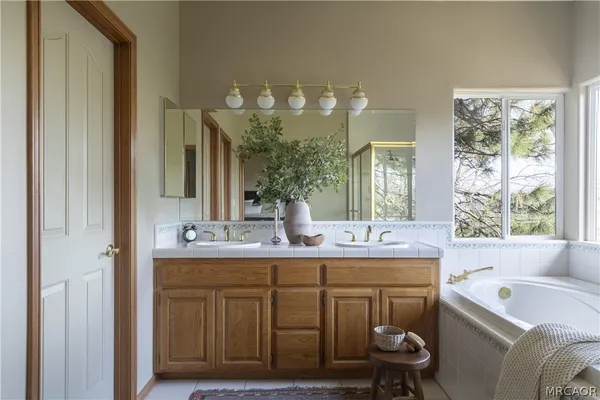 a bathroom with a tub sink and mirror