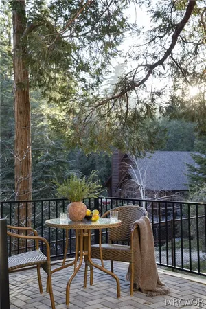 a roof deck view with table and chairs potted plants with wooden floor and fence