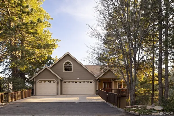 a front view of a house with yard and tree s
