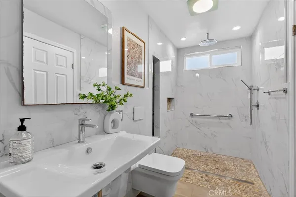 a bathroom with a sink a toilet and shower