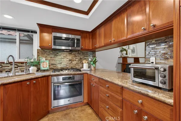 a kitchen with stainless steel appliances granite countertop a stove a sink and a microwave