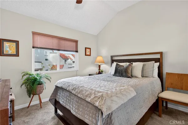 a bedroom with a large bed and a potted plant