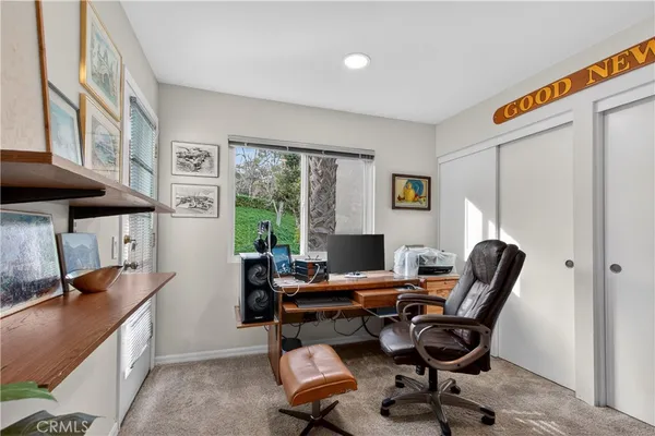a view of a workspace with furniture and a window