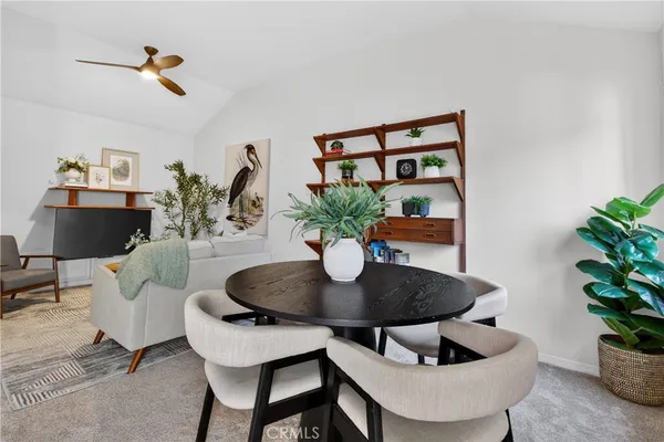 a dining room with furniture and a potted plant