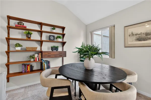 a view of a dining room with furniture and a potted plant